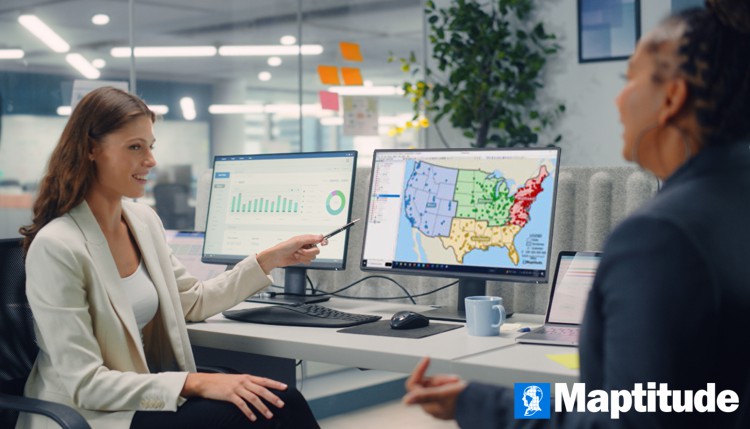 Employee using Maptitude GIS software on a desktop computer in an office setting